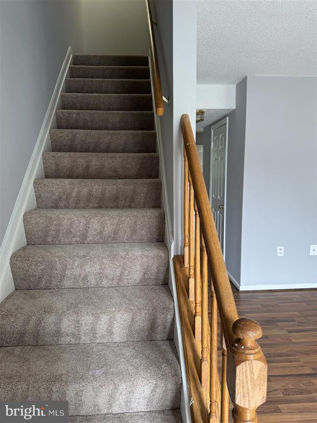 15368 Blacksmith Ter, Woodbridge, VA 22191 - stairs featuring wood finished floors, baseboards, and a textured ceiling