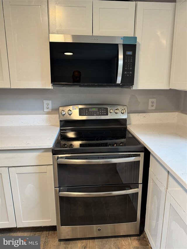 15368 Blacksmith Ter, Woodbridge, VA 22191 - kitchen with appliances with stainless steel finishes, white cabinetry, and wood finished floors