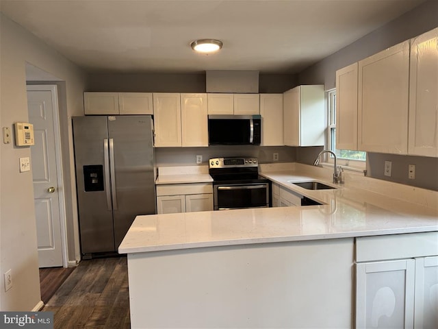 15368 Blacksmith Ter, Woodbridge, VA 22191 - kitchen with appliances with stainless steel finishes, a sink, dark wood-style floors, a peninsula, and light stone counters