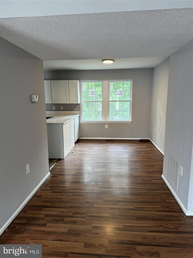 15368 Blacksmith Ter, Woodbridge, VA 22191 - unfurnished dining area featuring dark wood-type flooring, baseboards, and a textured ceiling