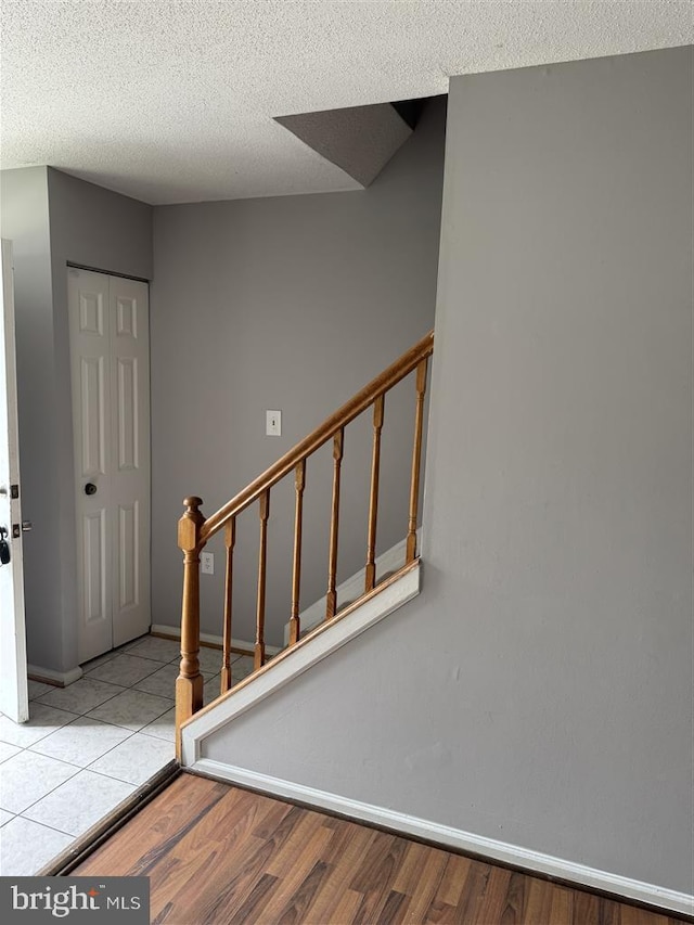 15368 Blacksmith Ter, Woodbridge, VA 22191 - entryway featuring light wood-style floors, stairs, a textured ceiling, and baseboards