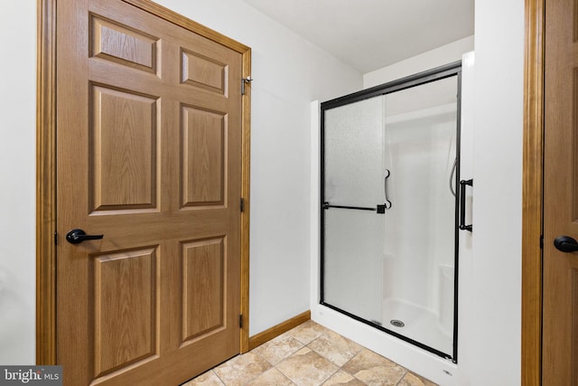 660 Bissetts Ln, Bloomsburg, PA 17815 - bathroom featuring a stall shower, baseboards, and stone finish flooring