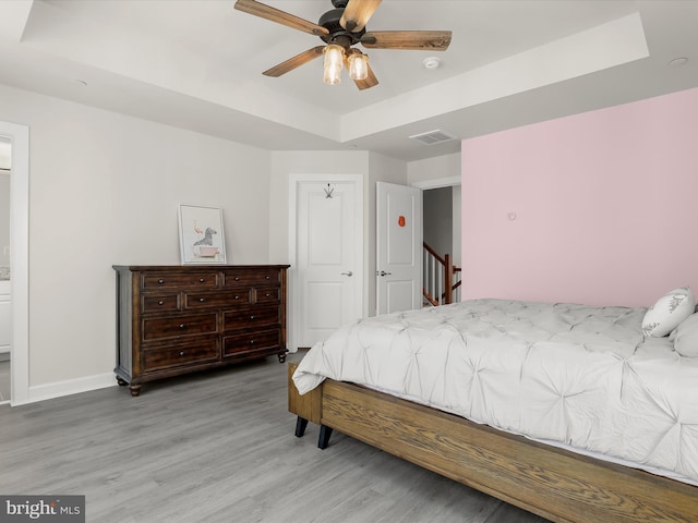 6021 Prairie Landing Way, Ellicott City, MD 21043 - bedroom featuring a tray ceiling, wood finished floors, and a ceiling fan