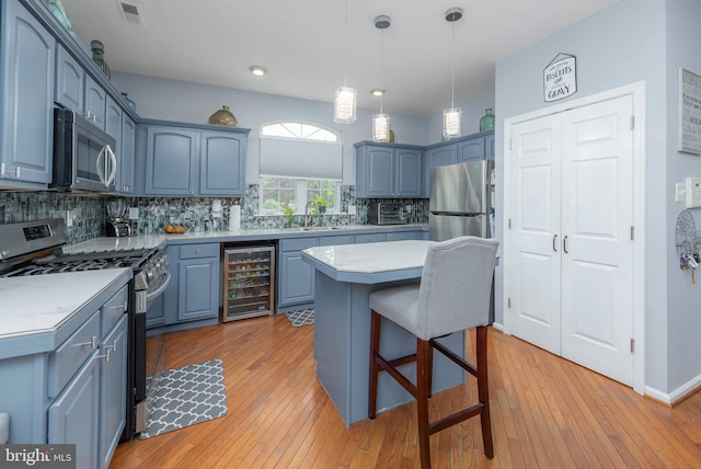 211 Spruce Trl, Woolwich Twp, NJ 08085 - kitchen featuring beverage cooler, appliances with stainless steel finishes, backsplash, a breakfast bar, and light countertops