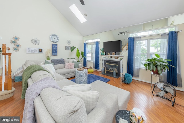 211 Spruce Trl, Woolwich Twp, NJ 08085 - living room with high vaulted ceiling, a skylight, wood finished floors, a fireplace with flush hearth, and ceiling fan