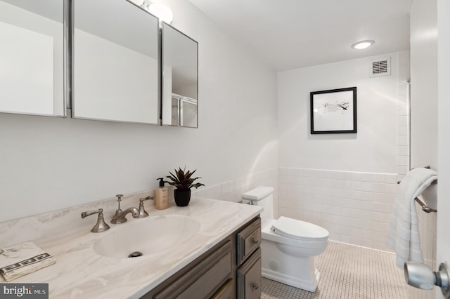 4100 Cathedral Ave NW Unit 709, Washington, DC 20016 - full bathroom with vanity, tile walls, tile patterned flooring, toilet, and a wainscoted wall