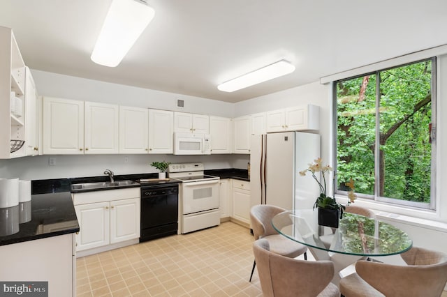 4100 Cathedral Ave NW Unit 709, Washington, DC 20016 - kitchen with white appliances, a sink, dark countertops, and white cabinetry