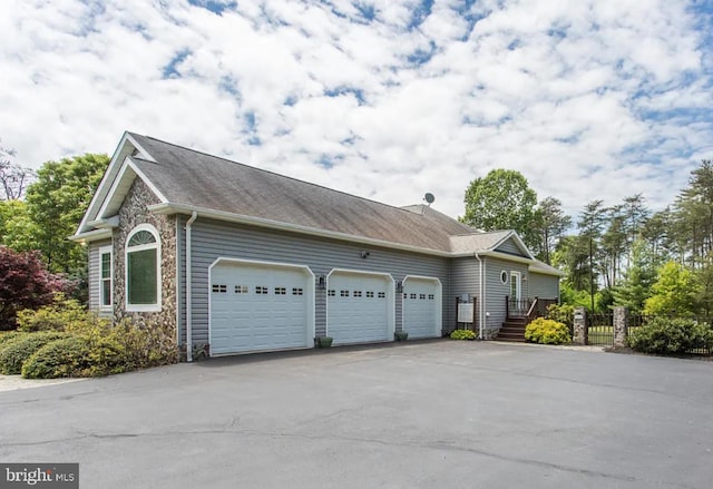 3420 Ponds Wood Ct, Huntingtown, MD 20639 - view of side of property featuring an attached garage, asphalt driveway, stone siding, and a shingled roof