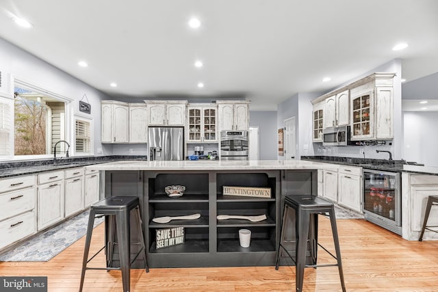 3420 Ponds Wood Ct, Huntingtown, MD 20639 - kitchen with appliances with stainless steel finishes, open shelves, a breakfast bar, wine cooler, and a center island