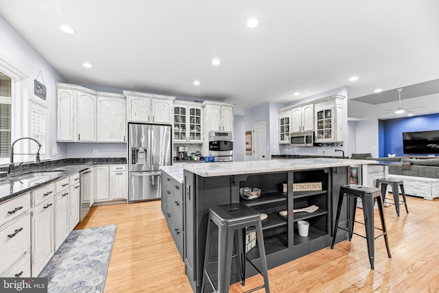 3420 Ponds Wood Ct, Huntingtown, MD 20639 - kitchen featuring stainless steel appliances, a sink, a breakfast bar area, light wood-style flooring, and recessed lighting