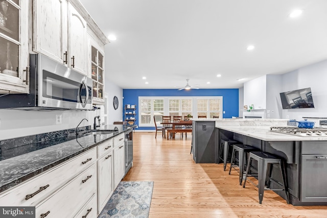 3420 Ponds Wood Ct, Huntingtown, MD 20639 - kitchen with stainless steel microwave, a breakfast bar area, light wood finished floors, recessed lighting, and a sink