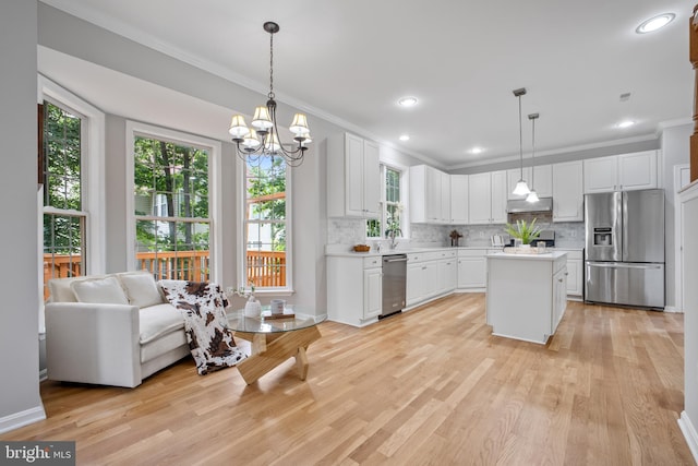 47561 Hidden Cove Ct, Sterling, VA 20165 - kitchen with appliances with stainless steel finishes, under cabinet range hood, light countertops, ornamental molding, and a chandelier