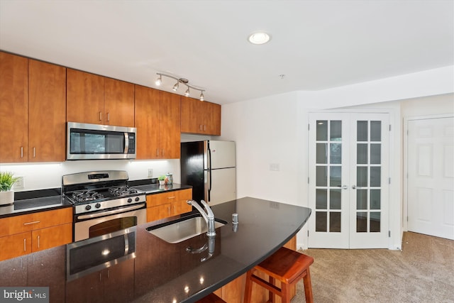 1136 Cove Rd Unit 202, Annapolis, MD 21403 - kitchen featuring appliances with stainless steel finishes, a sink, french doors, light carpet, and brown cabinetry