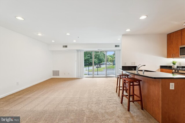 1136 Cove Rd Unit 202, Annapolis, MD 21403 - kitchen featuring dark countertops, light carpet, a breakfast bar, a sink, and recessed lighting