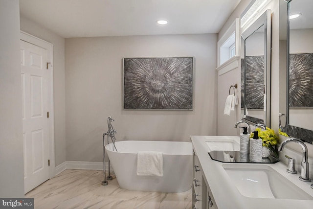 3402 Halloway S, Upper Marlboro, MD 20772 - bathroom with marble look tile flooring, a freestanding tub, double vanity, recessed lighting, and baseboards