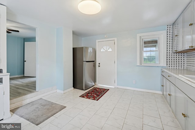 635 Elroy Rd, Souderton, PA 18964 - kitchen with freestanding refrigerator, light marble finish flooring, light countertops, white cabinetry, and a ceiling fan