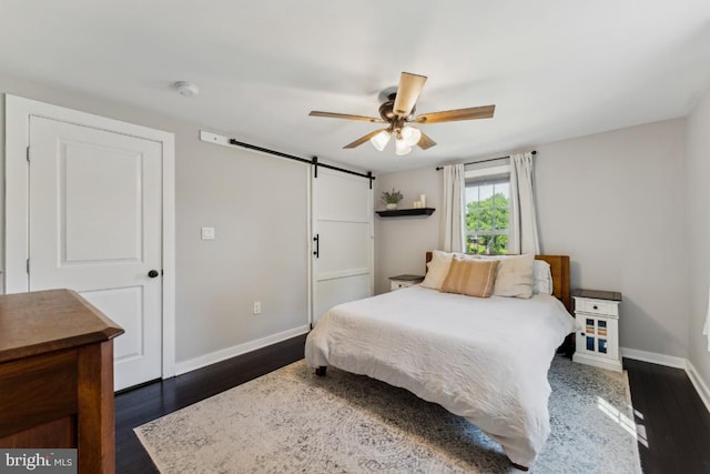 927 Annapolis Rd, Gambrills, MD 21054 - bedroom with baseboards, a barn door, dark wood-type flooring, and a ceiling fan