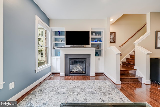 585 Regent Pl NE, Washington, DC 20017 - living room featuring wood finished floors, stairs, a glass covered fireplace, and baseboards