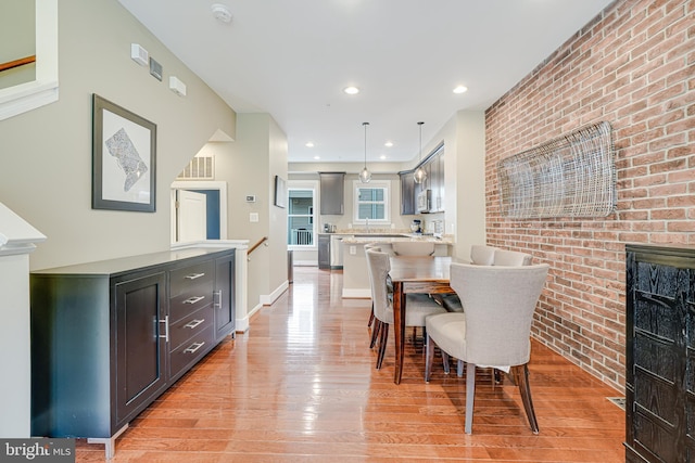 585 Regent Pl NE, Washington, DC 20017 - dining area featuring light wood-style flooring, brick wall, and recessed lighting