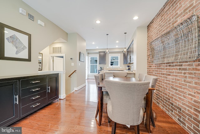 585 Regent Pl NE, Washington, DC 20017 - dining space featuring brick wall, light wood-type flooring, baseboards, and recessed lighting