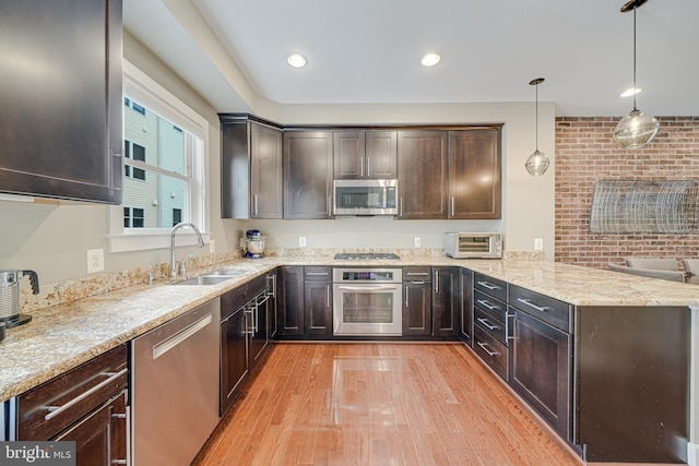 585 Regent Pl NE, Washington, DC 20017 - kitchen with stainless steel appliances, a sink, a peninsula, light wood-style floors, and dark brown cabinets