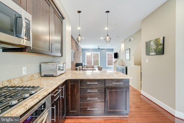 585 Regent Pl NE, Washington, DC 20017 - kitchen featuring stainless steel appliances, light wood-style floors, dark brown cabinets, a peninsula, and baseboards