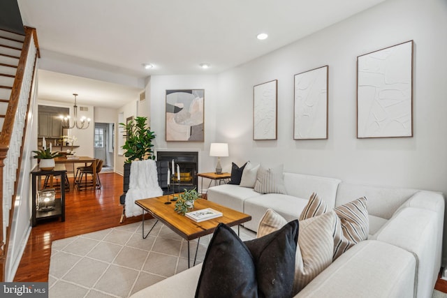 314 Monroe St, Philadelphia, PA 19147 - living area with wood finished floors, stairs, a chandelier, a glass covered fireplace, and recessed lighting