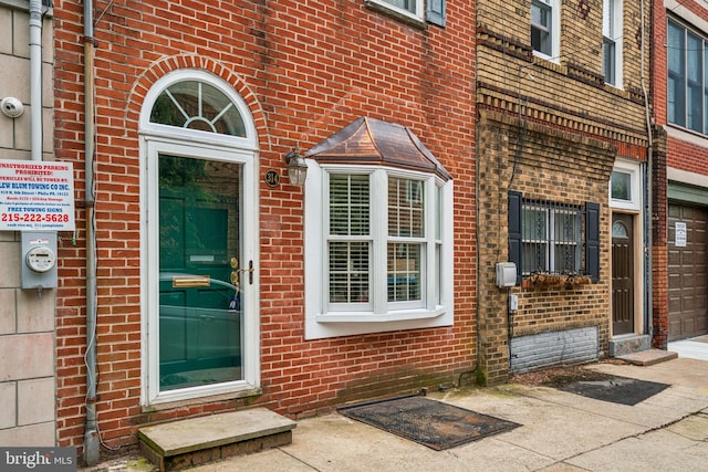 314 Monroe St, Philadelphia, PA 19147 - view of exterior entry featuring brick siding, driveway, and a security system