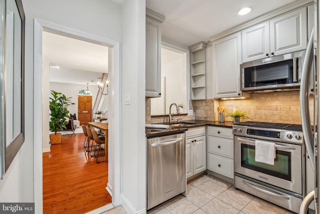 314 Monroe St, Philadelphia, PA 19147 - kitchen with stainless steel appliances, a sink, tasteful backsplash, open shelves, and white cabinets