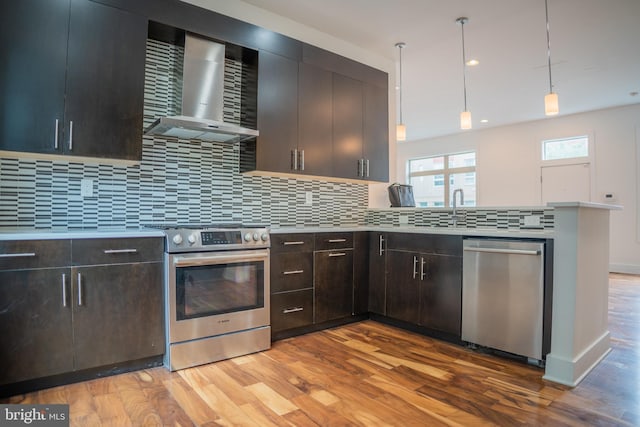 740 S Chris Columbus Blvd Unit 15, Philadelphia, PA 19147 - kitchen with appliances with stainless steel finishes, wall chimney range hood, light wood-style floors, light countertops, and decorative backsplash