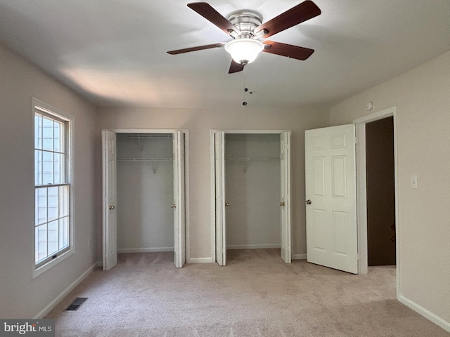 7930 Blue Gray Cir, Manassas, VA 20109 - unfurnished bedroom featuring two closets, multiple windows, light carpet, and a ceiling fan
