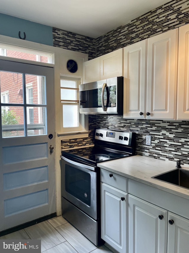 3401 Commonwealth Ave Unit A, Alexandria, VA 22305 - kitchen featuring stainless steel appliances, decorative backsplash, light countertops, and white cabinets