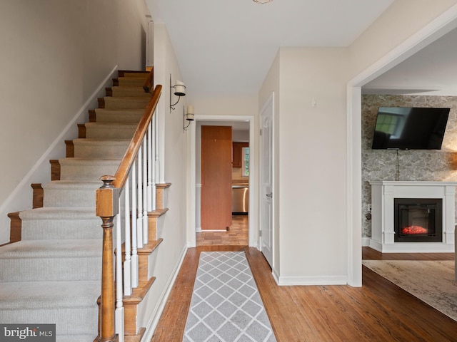 1401 Glenside Rd, Downingtown, PA 19335 - stairway with wood finished floors, a glass covered fireplace, and baseboards