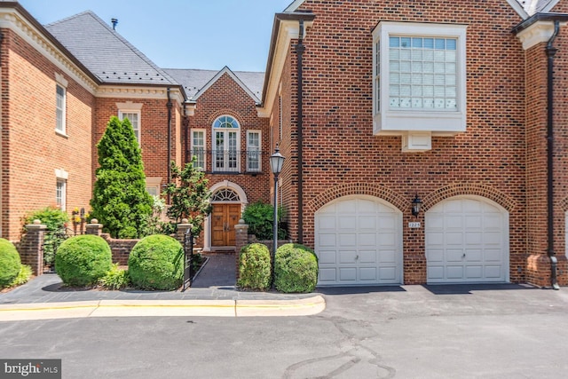 1225 Stuart Robeson Dr, Mclean, VA 22101 - view of front of property with brick siding, an attached garage, driveway, and a high end roof