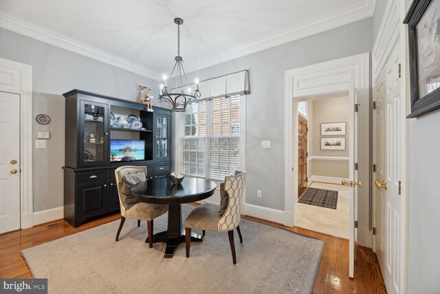 1225 Stuart Robeson Dr, Mclean, VA 22101 - dining area featuring a chandelier, wood finished floors, crown molding, and baseboards