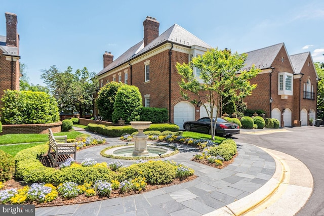 1225 Stuart Robeson Dr, Mclean, VA 22101 - view of side of property with an attached garage, brick siding, a chimney, a high end roof, and asphalt driveway