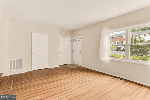 2053 Wintergreen Pl, Rosedale, MD 21237 - empty room featuring light wood finished floors, baseboards, and a textured ceiling