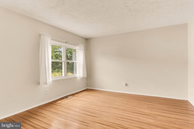 2053 Wintergreen Pl, Rosedale, MD 21237 - empty room with light wood-type flooring, a textured ceiling, and baseboards