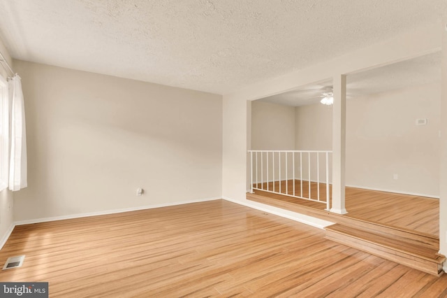 2053 Wintergreen Pl, Rosedale, MD 21237 - empty room featuring light wood-type flooring, a ceiling fan, a textured ceiling, and baseboards