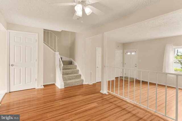 2053 Wintergreen Pl, Rosedale, MD 21237 - spare room with a textured ceiling, wood finished floors, ceiling fan, stairs, and baseboards