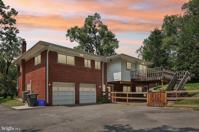 9307 Overlea Dr, Rockville, MD 20850 - view of front of property with an attached garage, a chimney, asphalt driveway, brick siding, and central air condition unit