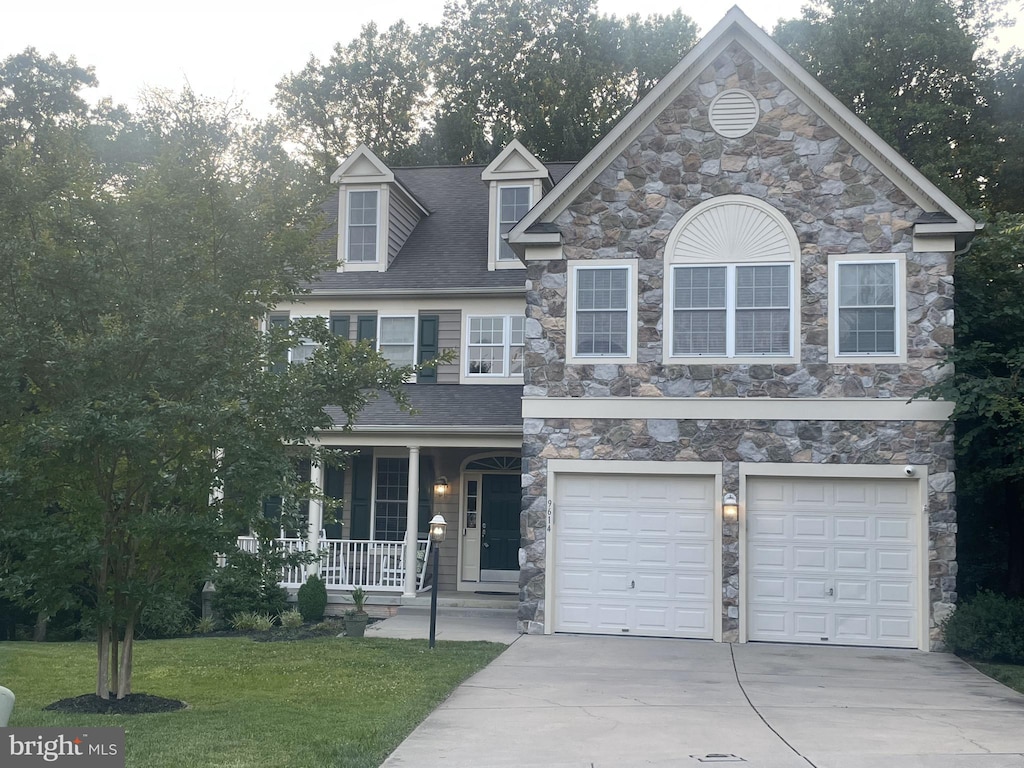 9614 Meadow Flowers Ct, Laurel, MD 20723 - view of front of property featuring a porch, driveway, stone siding, an attached garage, and a front yard