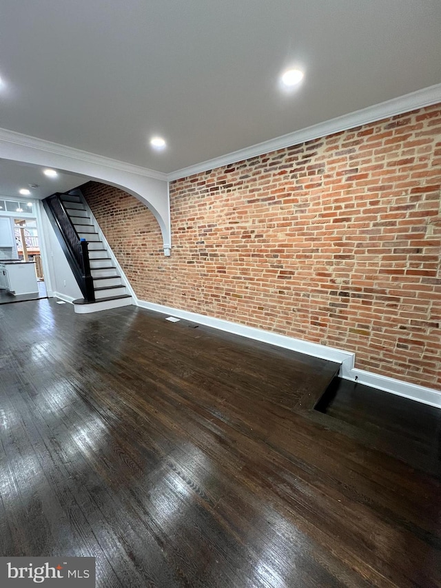 736 S Curley St, Baltimore, MD 21224 - unfurnished living room with brick wall, stairway, hardwood / wood-style floors, baseboards, and crown molding