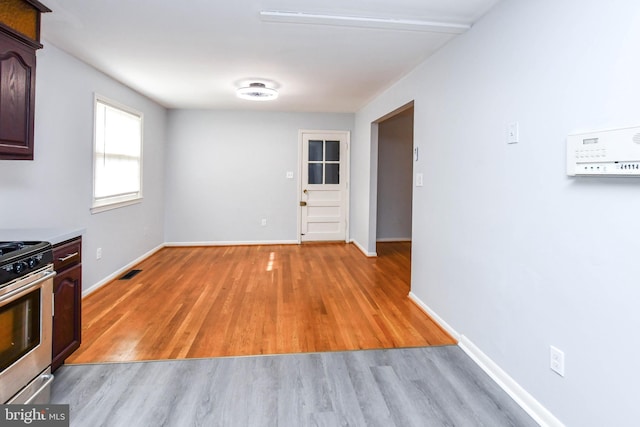 10903 Exeter Ct, Upper Marlboro, MD 20774 - kitchen with gas stove, light wood-style flooring, baseboards, dark brown cabinets, and light countertops