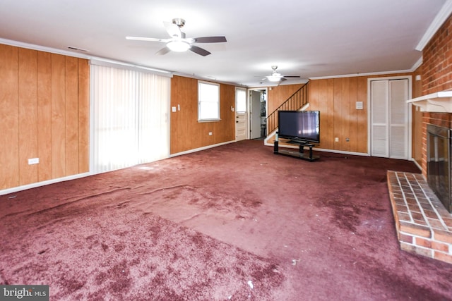 10903 Exeter Ct, Upper Marlboro, MD 20774 - unfurnished living room featuring a ceiling fan, a fireplace, stairs, crown molding, and wooden walls