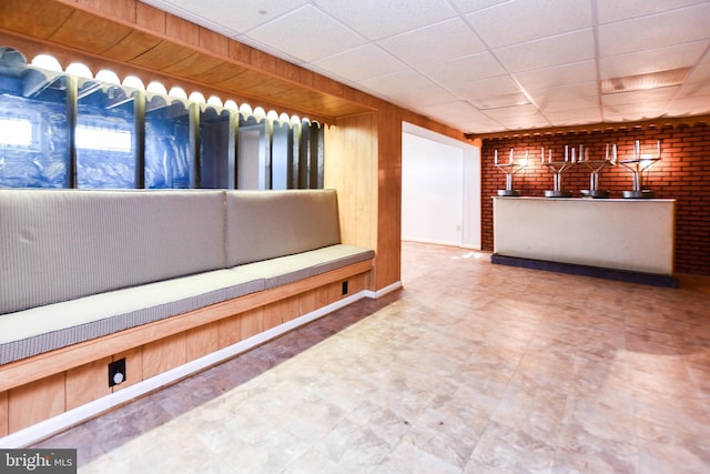 10903 Exeter Ct, Upper Marlboro, MD 20774 - bar area featuring a paneled ceiling, wooden walls, brick wall, and tile patterned floors