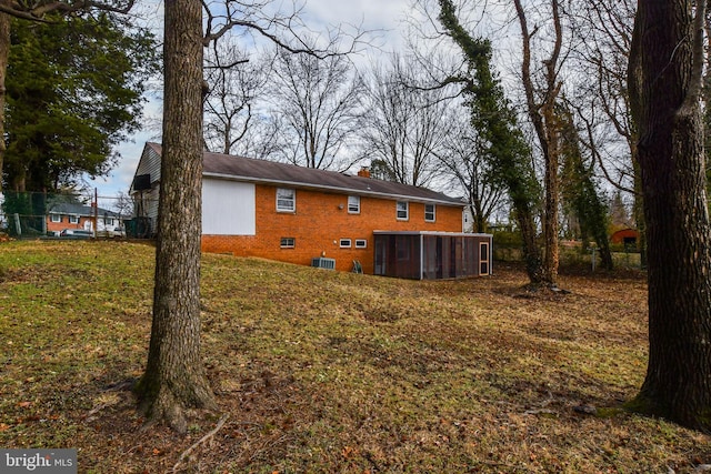 10903 Exeter Ct, Upper Marlboro, MD 20774 - rear view of house with brick siding, a sunroom, a chimney, and a lawn