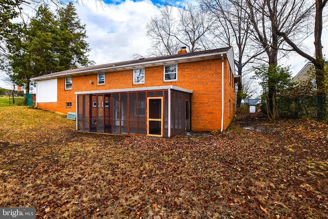 10903 Exeter Ct, Upper Marlboro, MD 20774 - rear view of house with a sunroom, brick siding, and a chimney