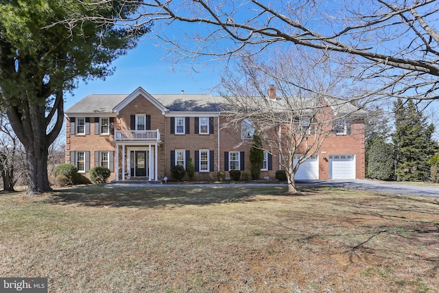 5512 Aspen Dale Ct, Ellicott City, MD 21043 - colonial house with a balcony, brick siding, asphalt driveway, a front lawn, and a chimney