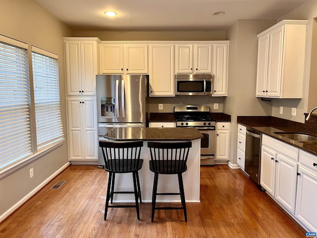 2733 Aldersgate Way, Charlottesville, VA 22911 - kitchen with stainless steel appliances, a sink, white cabinetry, wood finished floors, and recessed lighting
